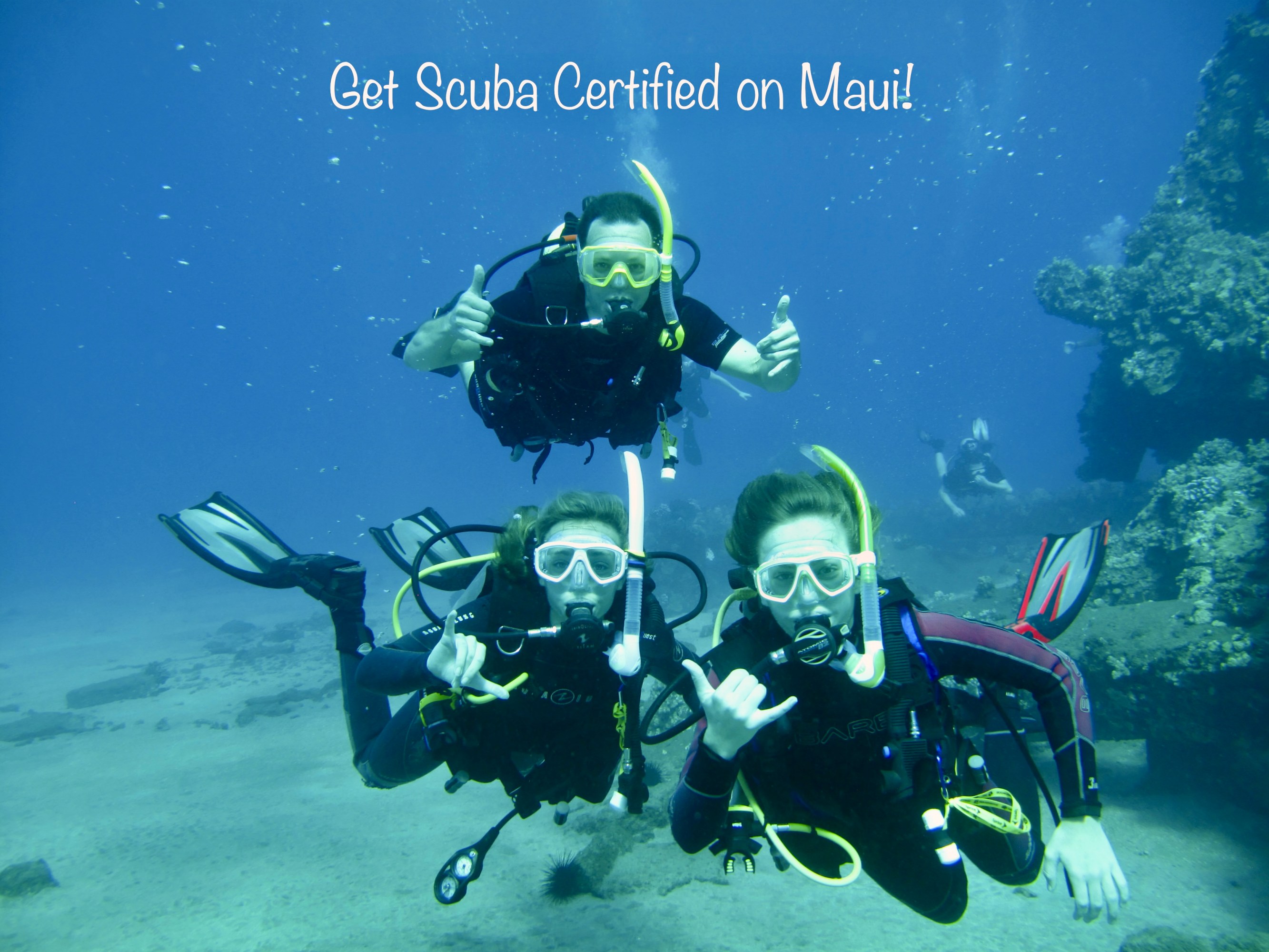 Three scuba divers posing underwater with shaka signs beneath the words “Get Scuba Certified on Maui!”