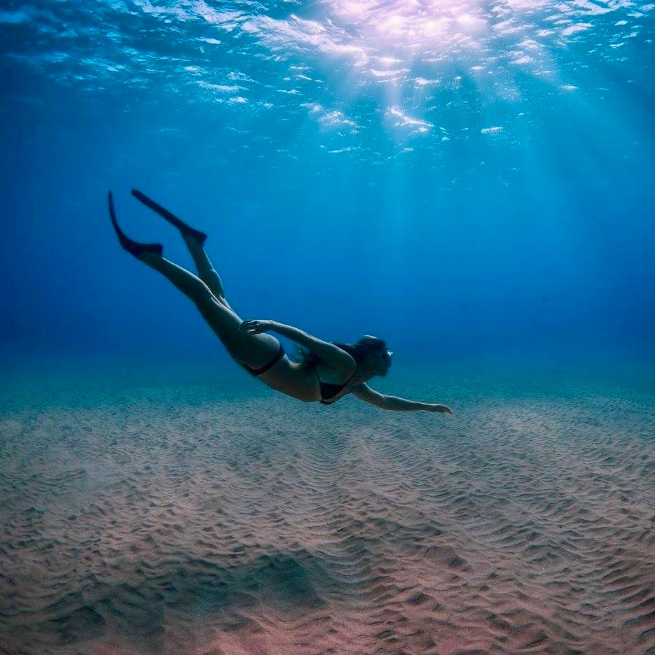 Snorkeler swimming over a sandy bottom in Ka'anapali, Maui.
